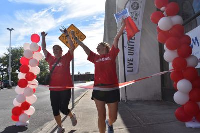 Two women with arms in air cross the finish line
