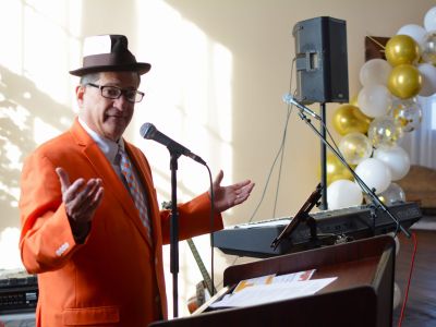 a man dressed up in a suit giving a speach at a formal event