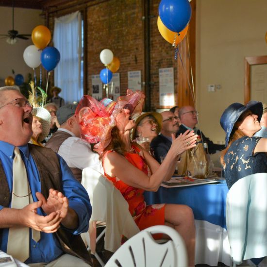 People dressed up at a formal party, clapping