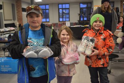 Smiling kids holding their new shoes