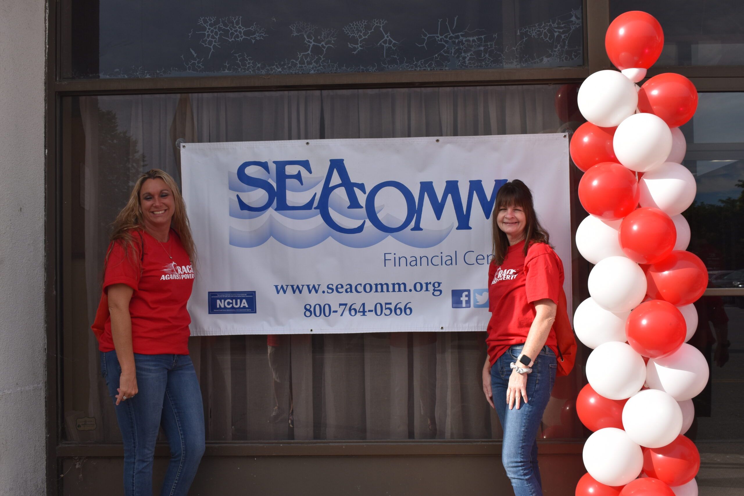 Representatives from SeaComm, a presenting sponsor, pose with their banner