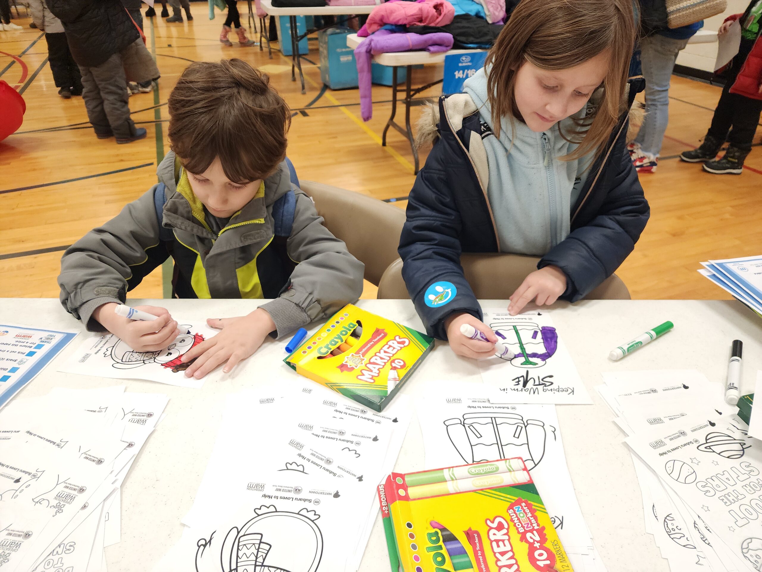 Two children coloring on a large table