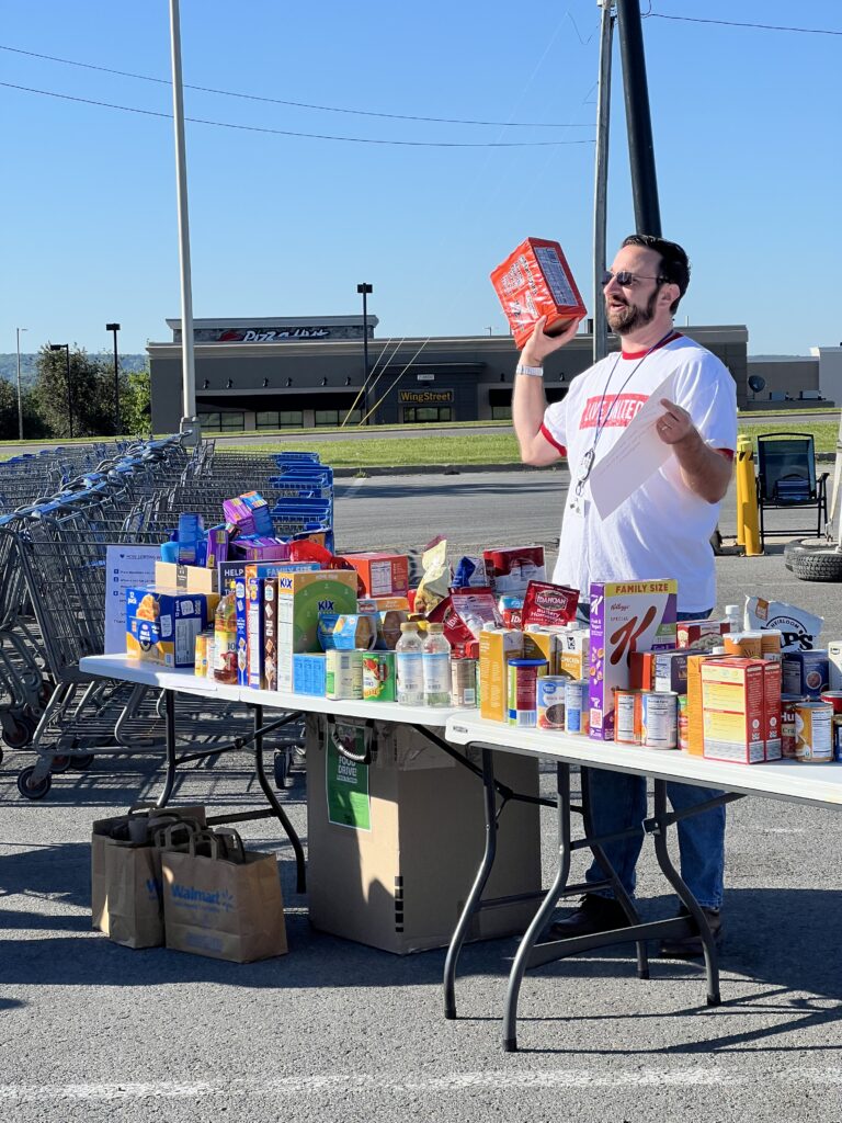 Lead volunteer provides instruction at the food table.