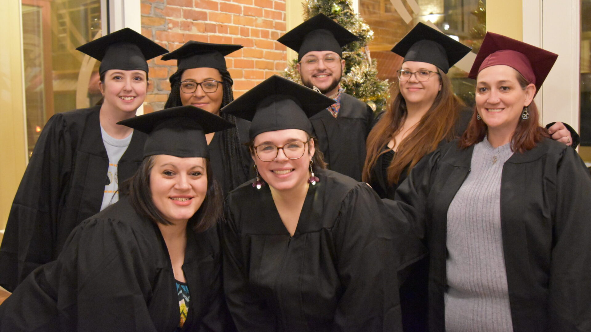 Group of workshop graduates dressed in caps and gowns
