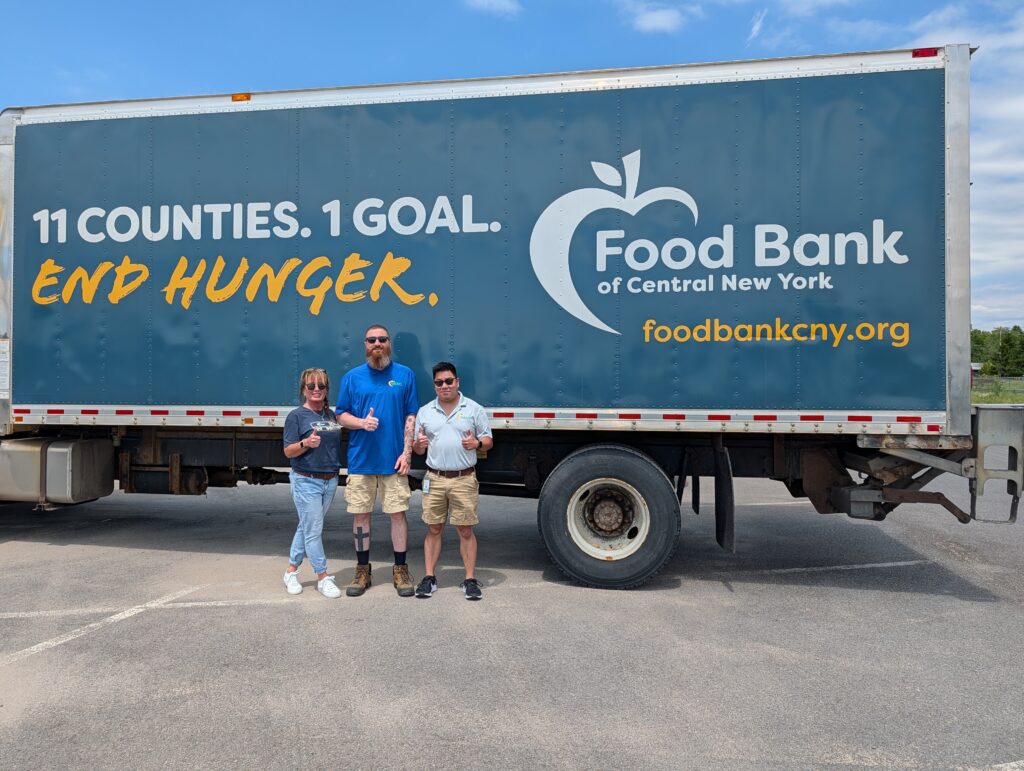 Food Bank of CNY crew pose in front of truck.