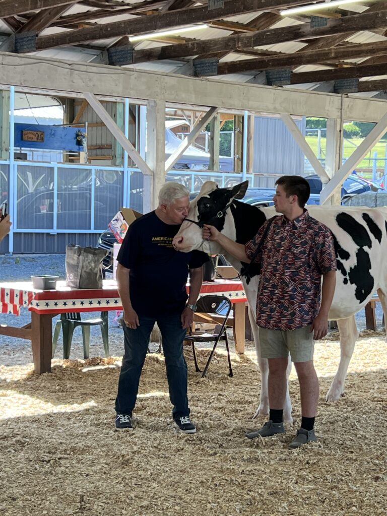 Lee Hinkleman leans in to kiss a cow.