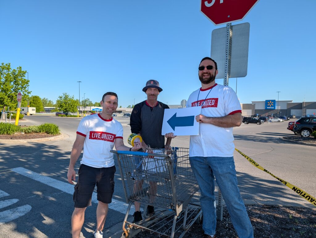Volunteers put up arrows to help direct traffic at food drive event.