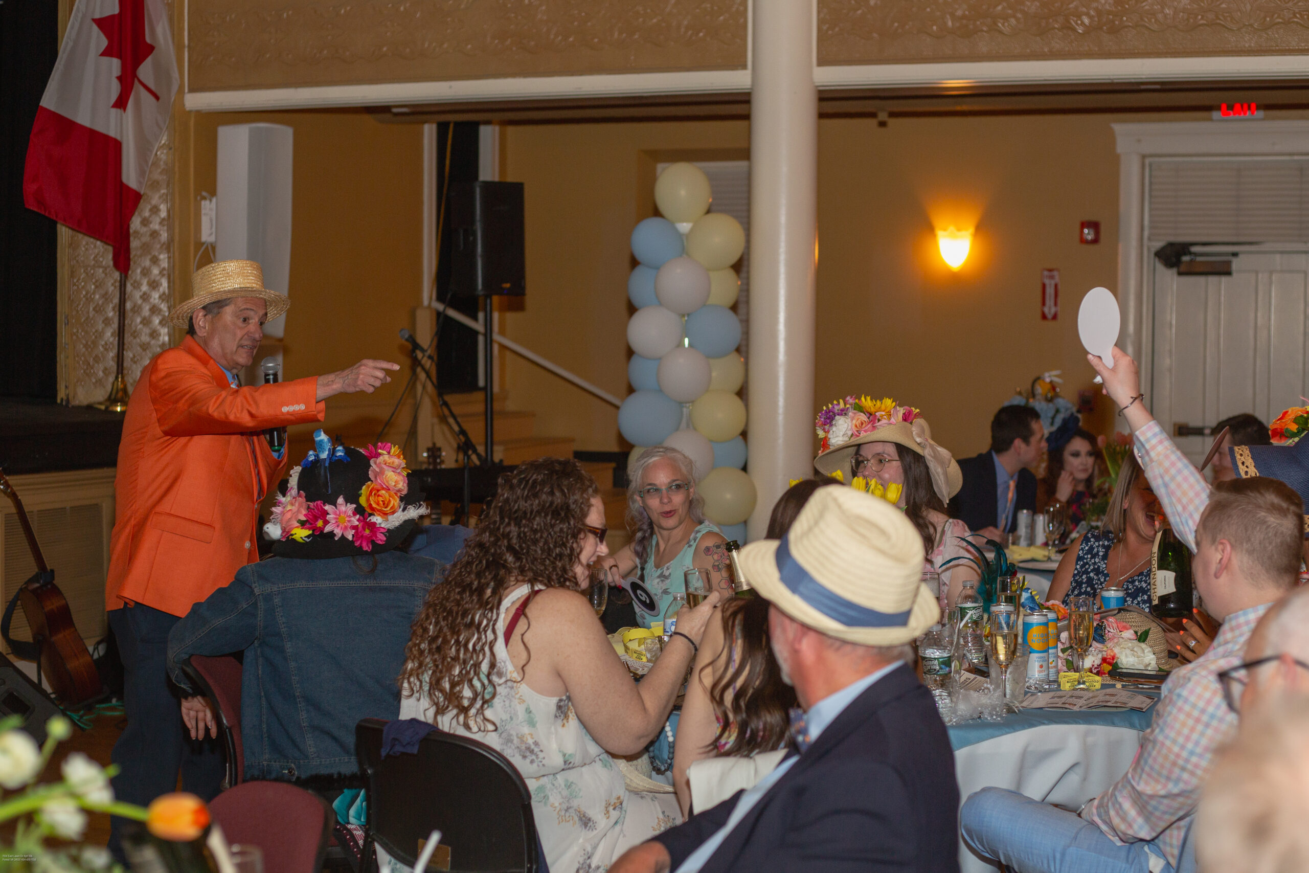 Gentleman in crowd raises his paddle for an auction bid