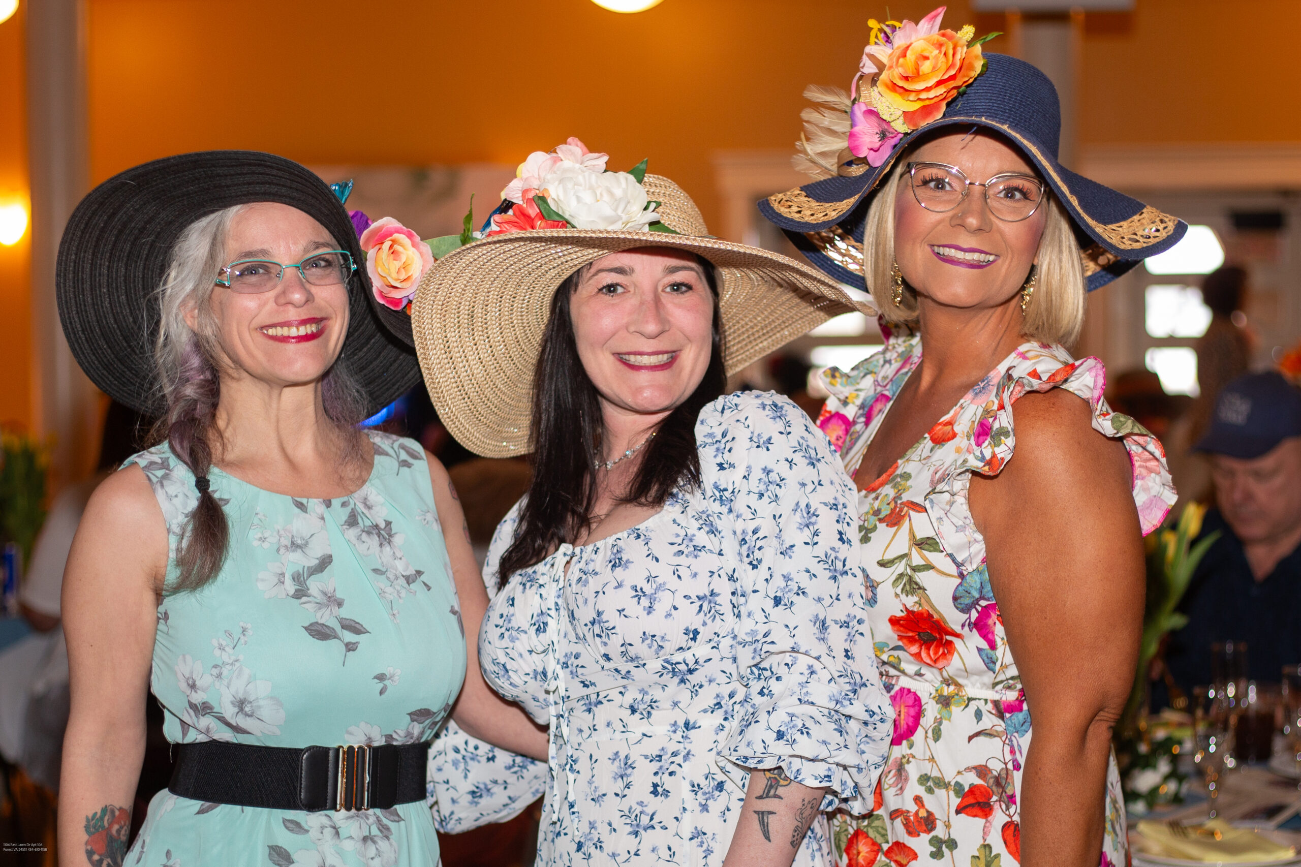 Three ladies attending the derby in hats and floral dresses
