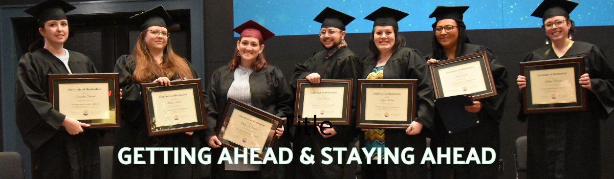 Group of individuals in cap and gowns posed with graduation certificates