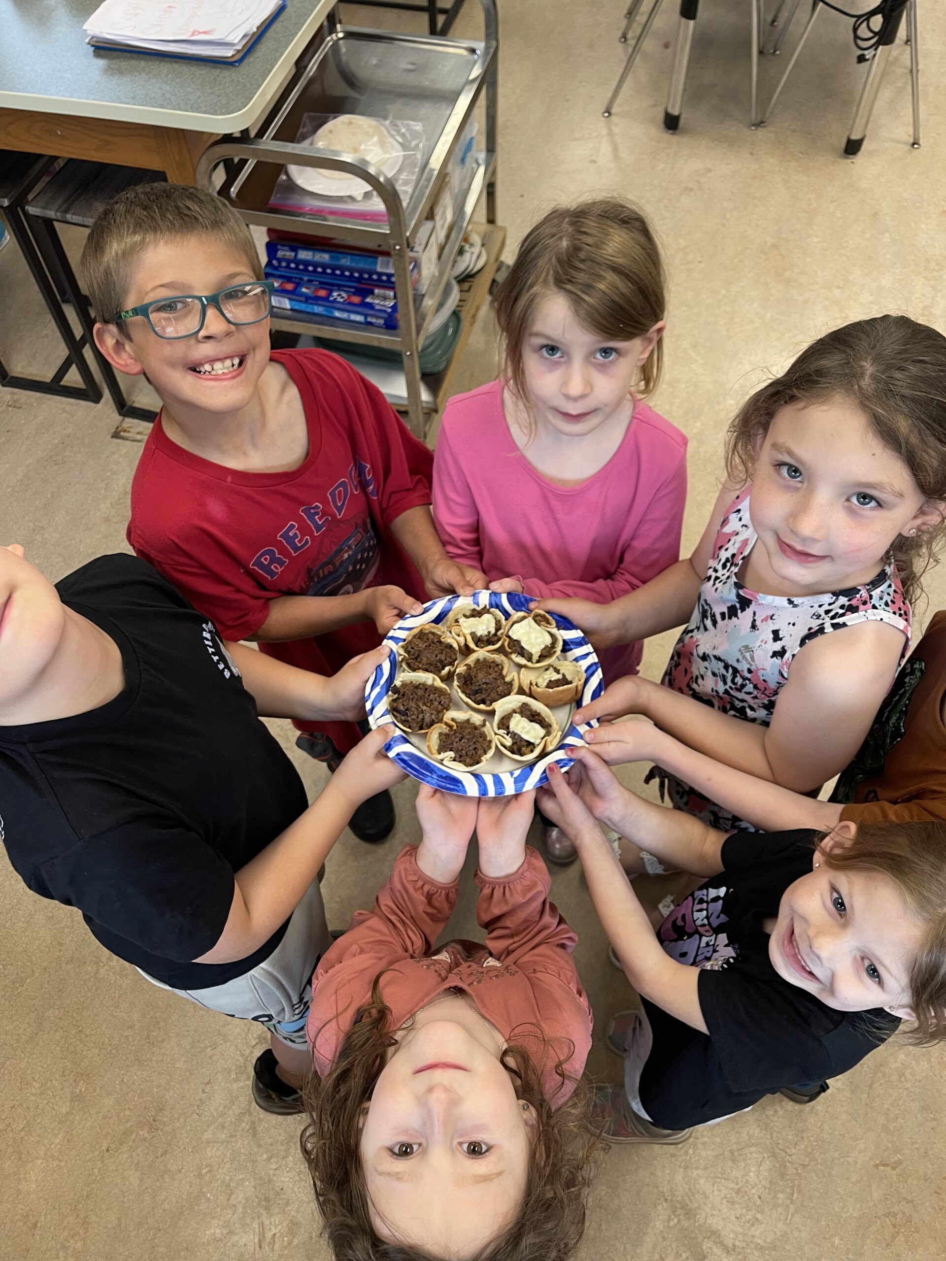 Kids in circle holding plate of homemade brownies