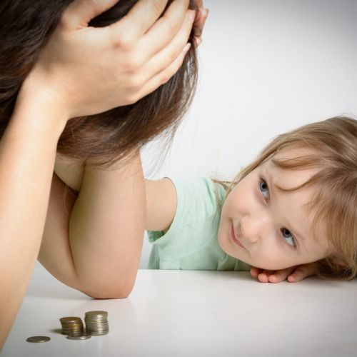 small girl looking up a lady with her head in her hands