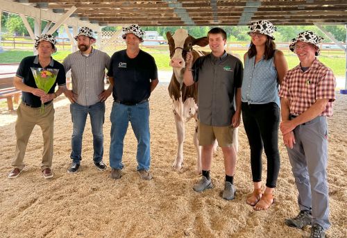 2025 cow kissing team assembles with Miss Jenn, the cow.